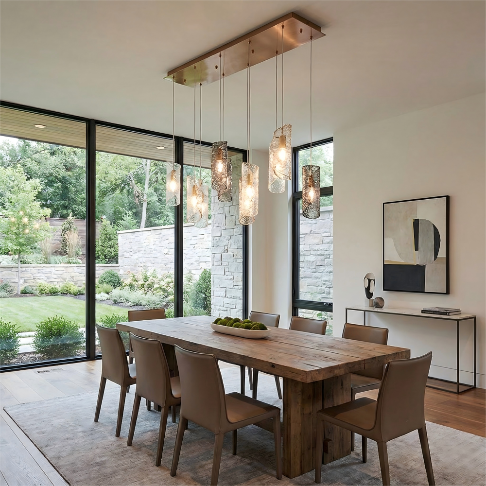 Modern dining room with wooden table and chairs, large windows, and decorative light fixtures.