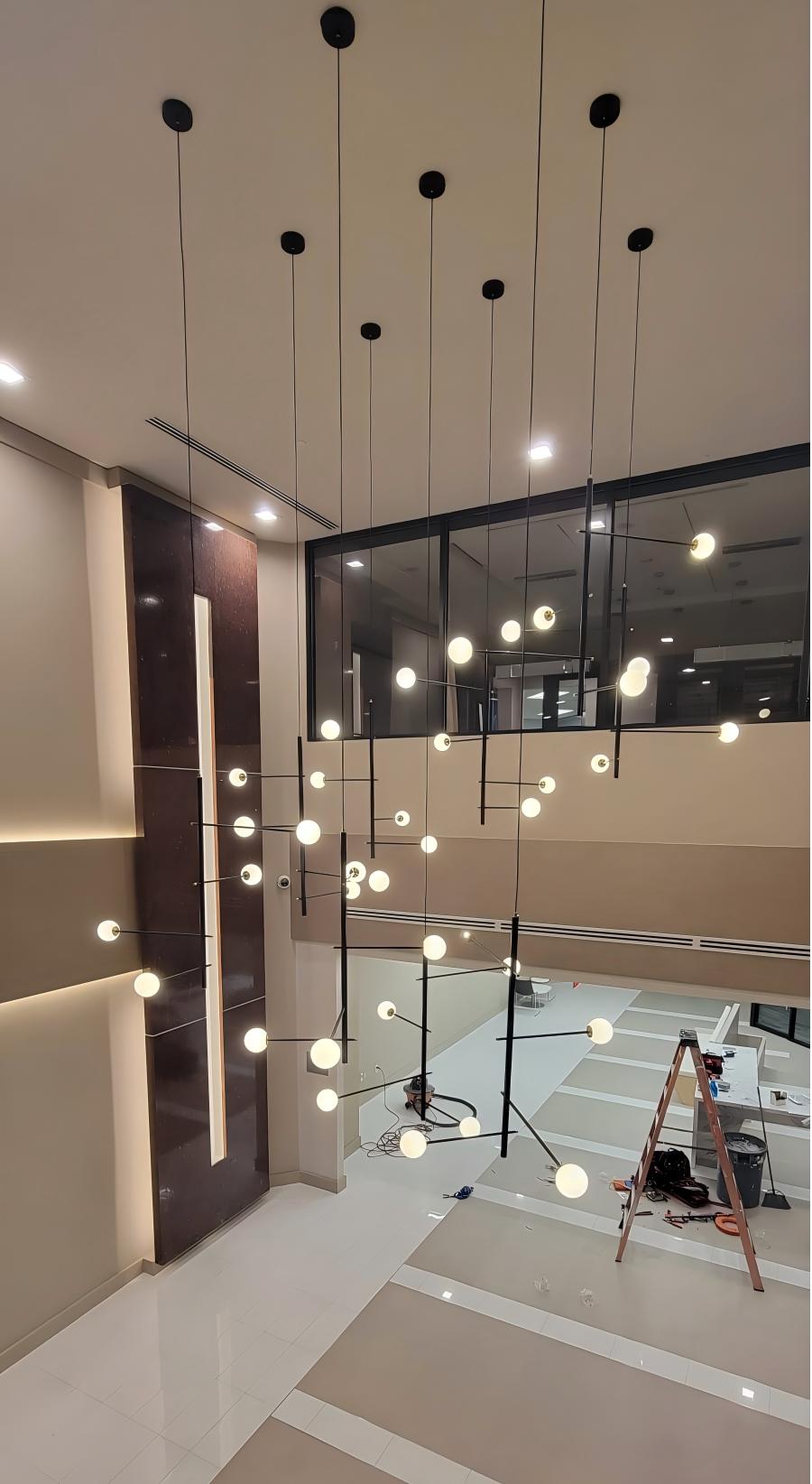 Close-up of white glass globes on the 36-light hanging cable style chandelier.