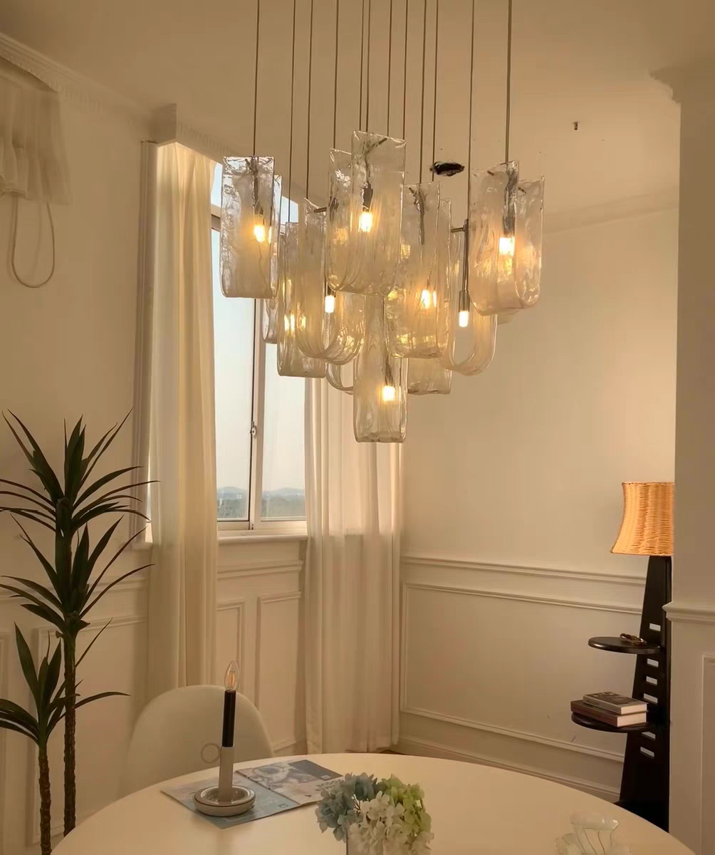 Warm lighting of Nebula Wave Chandelier above the dining room table, creating a inviting style