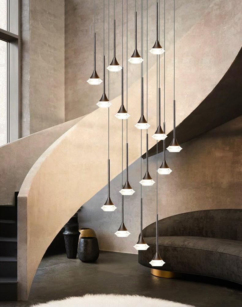 A series of pendant LED lights with a chrome metal frame and glass diffusers, installed in a spiral pattern over a staircase with a black canopy and a round lighting source.