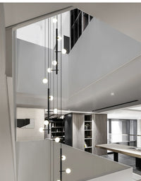 Thumbnail for Side view of the 32-light hanging cable style chandelier on the staircase setting.