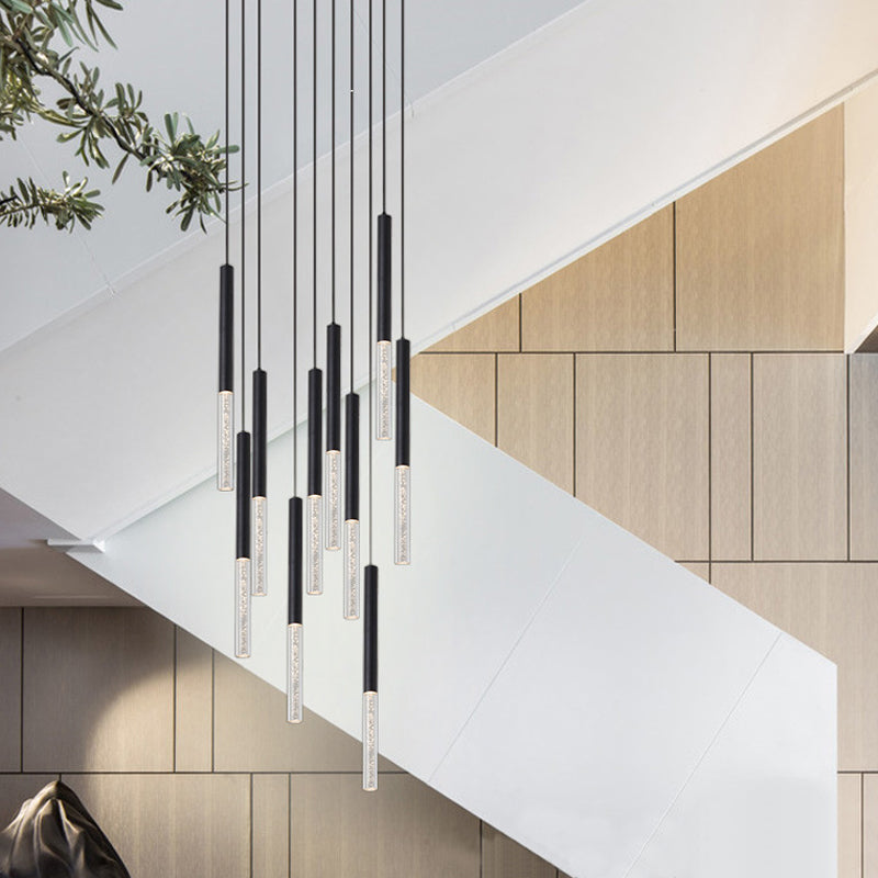 A modern multi-pendant crystal chandelier with black and white pendants hanging from a white geometric ceiling fixture.