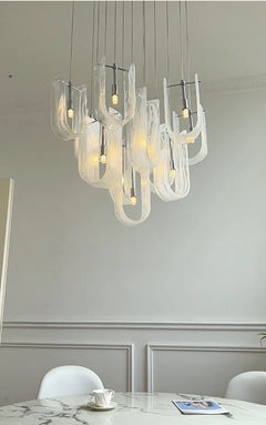 Modern dining area with installed Nebula Wave Chandelier, creating an elegant focal point