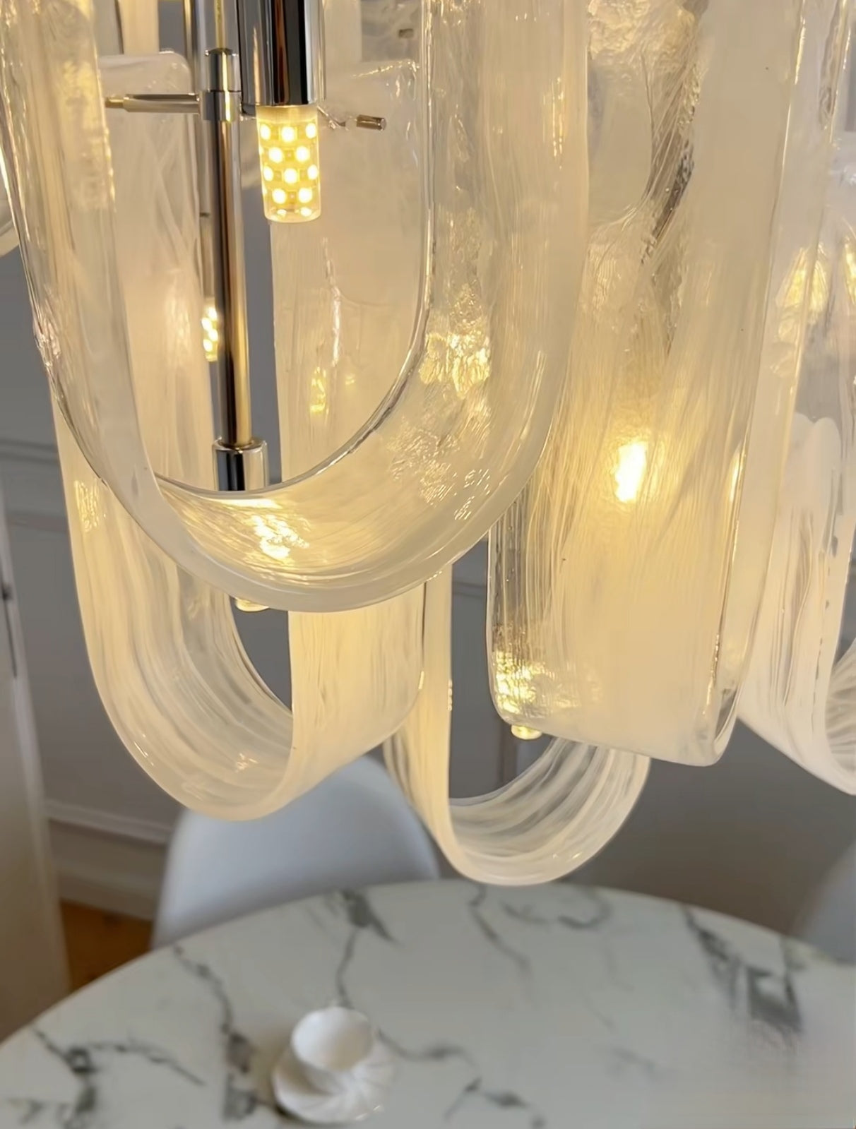 Close-up of hand-blown frosted glass pendants on Nebula Wave Chandelier