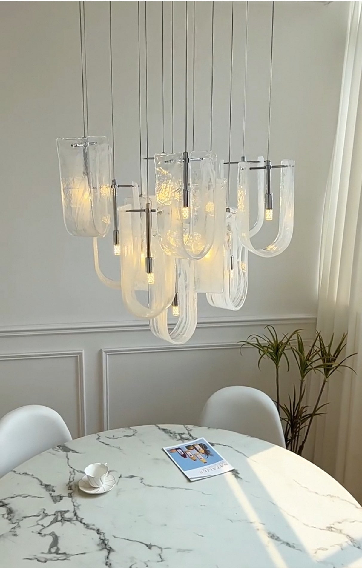Modern dining area with installed Nebula Wave Chandelier