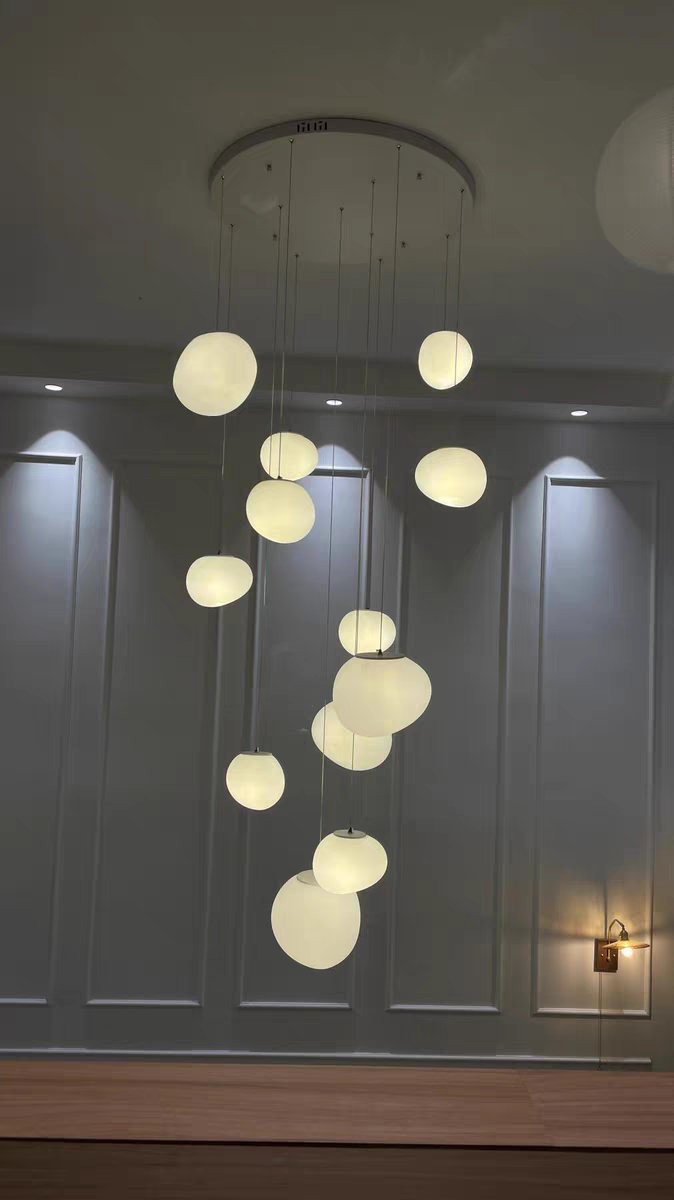Atmospheric shot of the Luminous Pebble pendant creating a calm and inviting glow in an evening setting.
