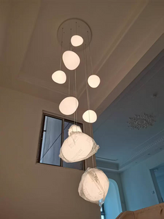 Illuminated Luminous Pebble pendant emitting a soft, diffused warm white glow, highlighting its organic shape.