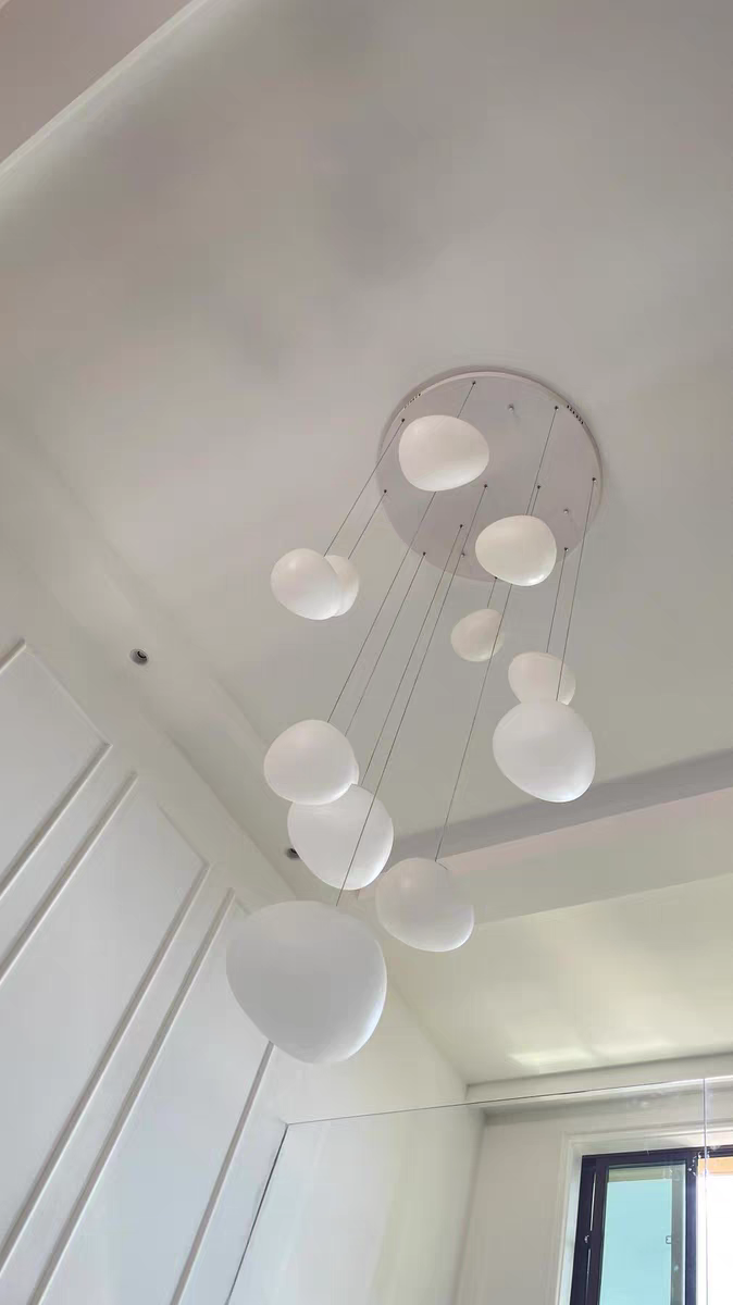 Lifestyle image of the Luminous Pebble pendants in a cozy reading nook, providing focused illumination.