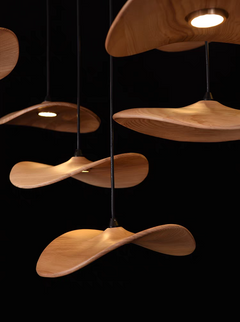 The wooden shade chandelier casting a soft, focused light, highlighting its natural wood grain detail.