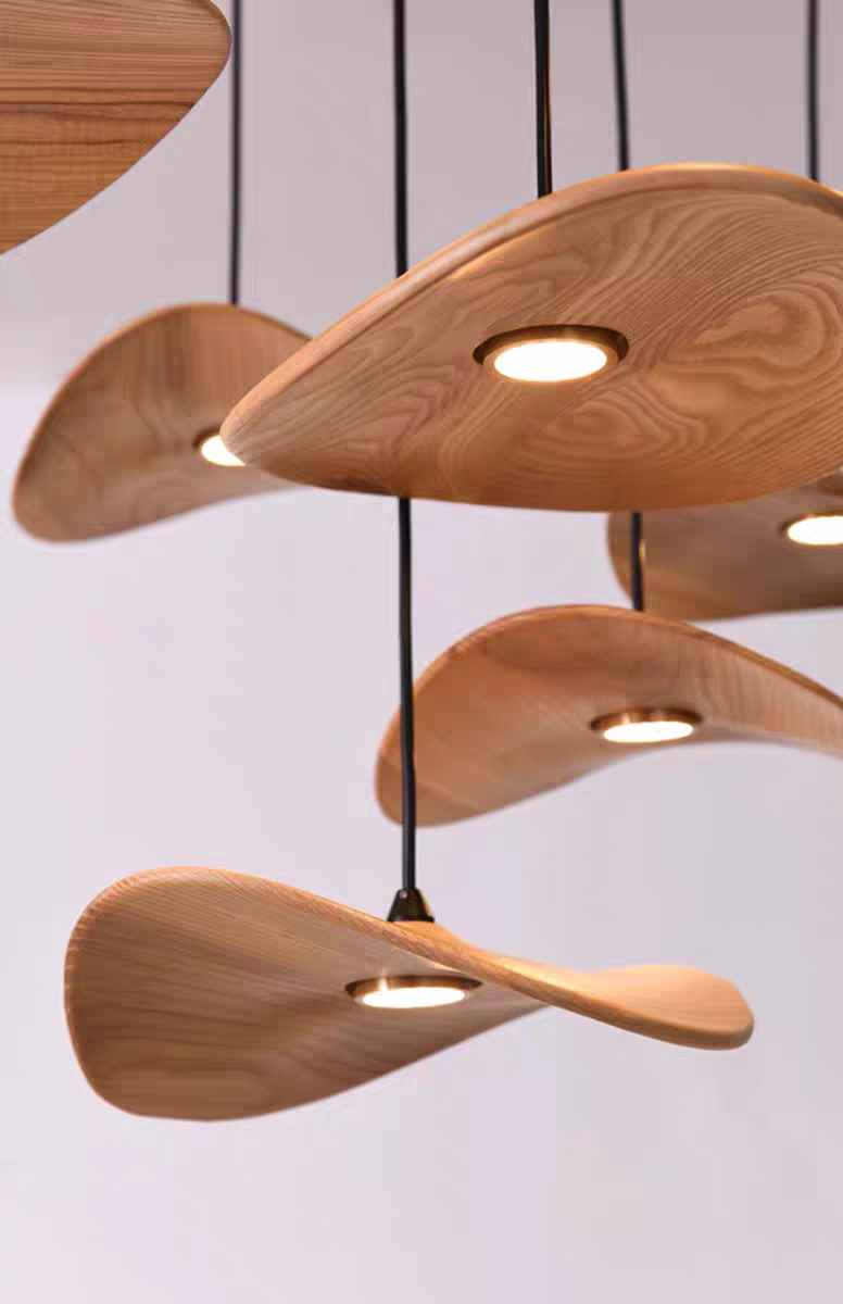Close-up detail of the light wooden shades and black metal structure of the Nordic style chandelier.