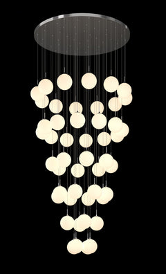 A contemporary glass globe chandelier with multiple round opal glass shades and satin metal details, hanging from a circular metal canopy.