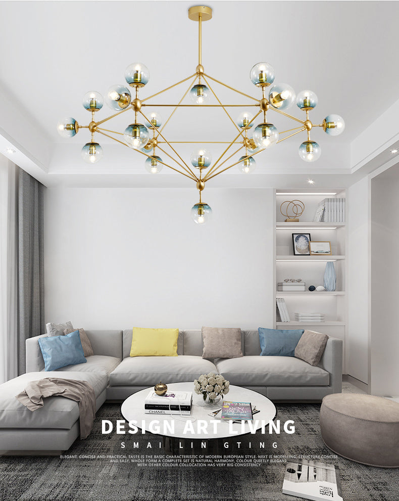 Modern glass molecular chandelier with gold and black accents, featuring multiple globe-shaped lights, suspended over a living room setting with a gray sofa and blue cushions.