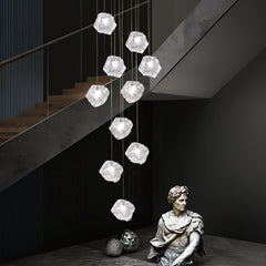 Dynamic low-angle shot of the Aria Sculptural Chandelier, showcasing the cascading arrangement of its 10 stone glass globes.