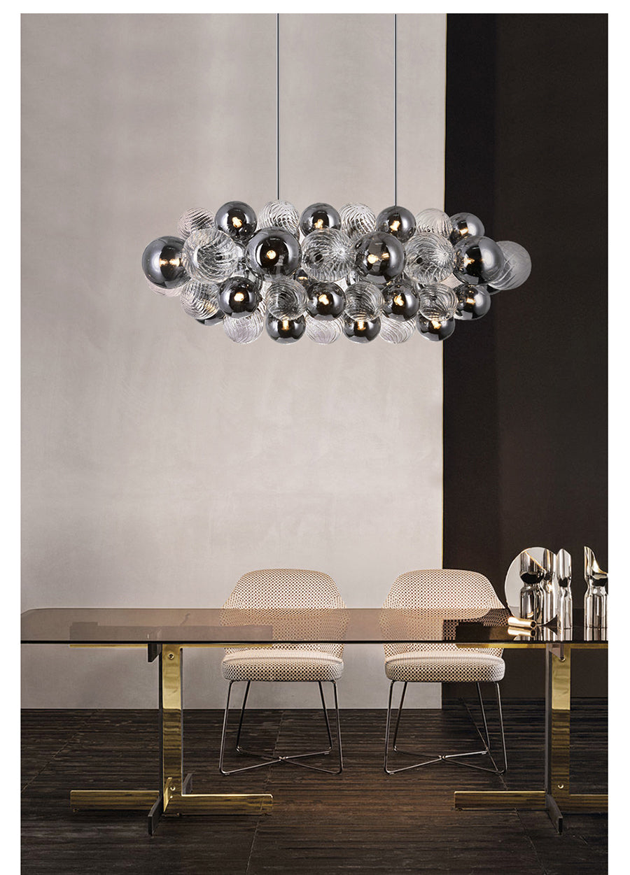 Top view of the 28-light chandelier over a dining table, showing its rectangular arrangement of glass shades.