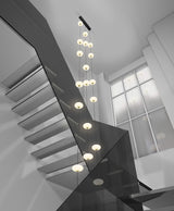 An oval pendant light with a frosted white and gold finish, featuring a series of LED lights hung in a staircase with a black canopy.